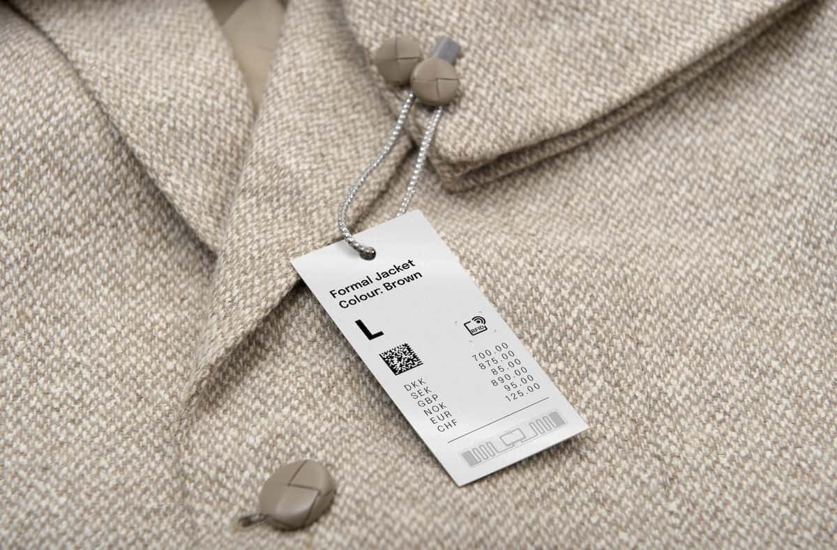 Etiqueta RFID colgante en chaqueta de retail utilizada para identificación, trazabilidad y gestión inteligente de inventario.