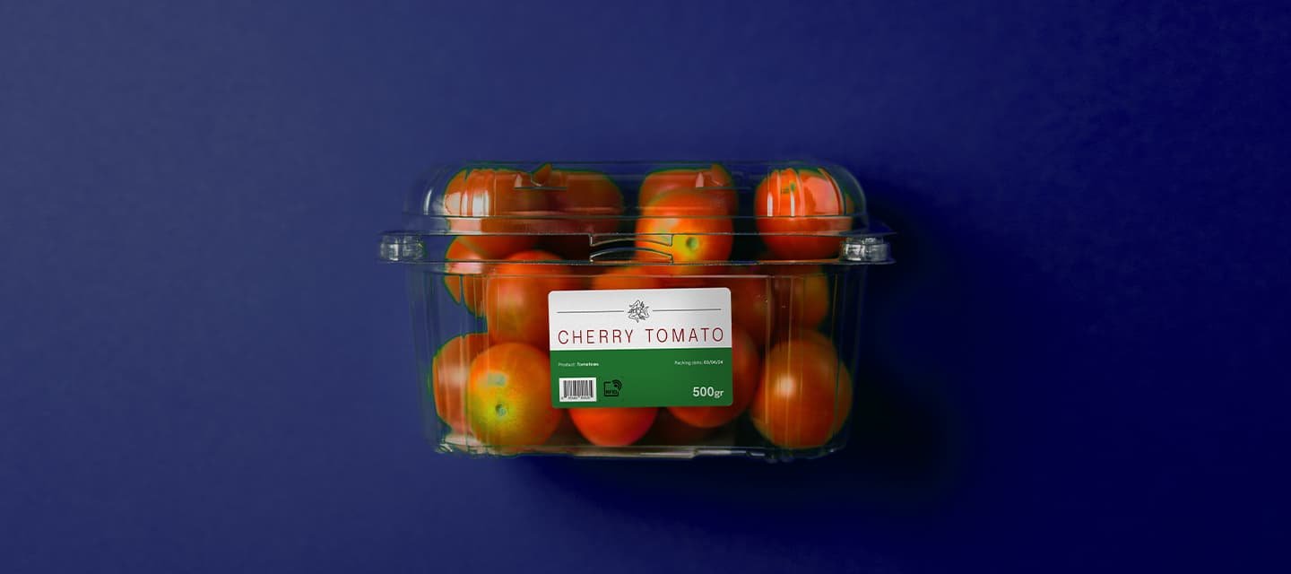 Cherry tomato packaging with a clear container and product sticker, illustrating types of self adhesive labels used in fresh food packaging.